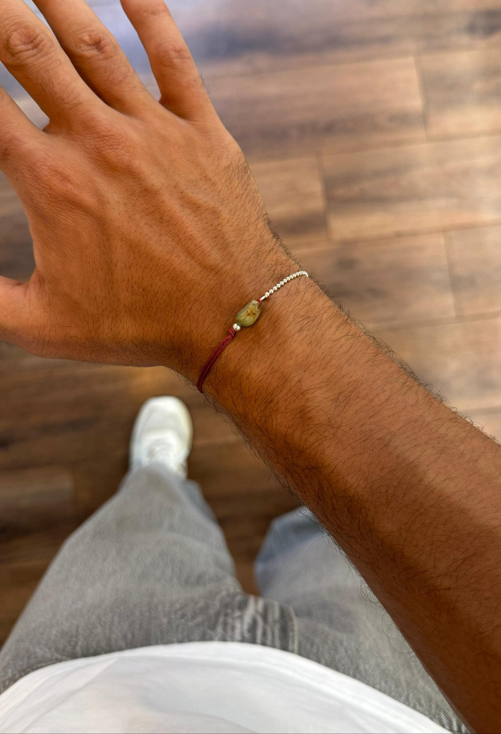 Hand with a bracelet on a wooden floor