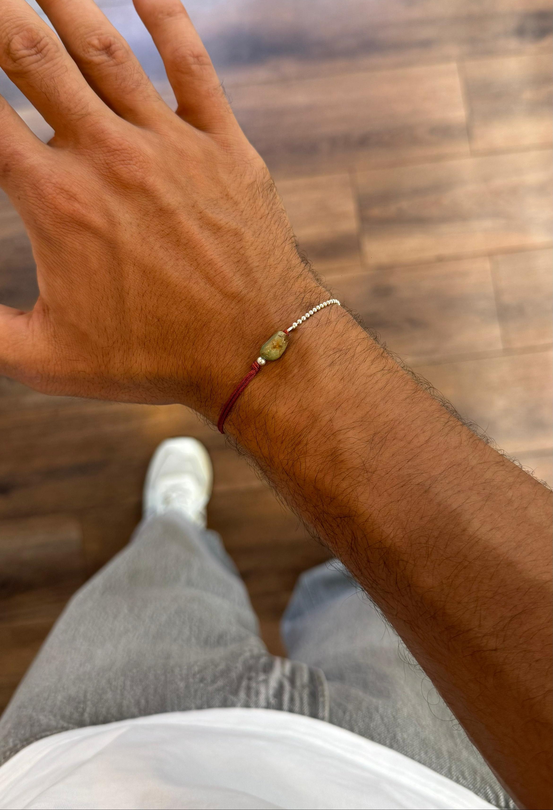 Hand with a bracelet on a wooden floor